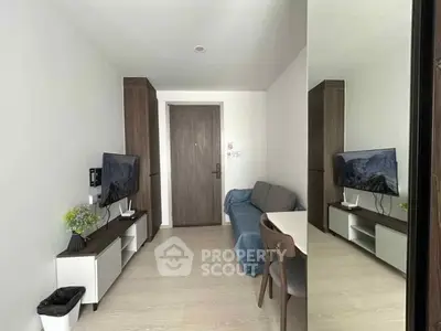 Modern living room with sleek furniture and wall-mounted TV in a cozy apartment.