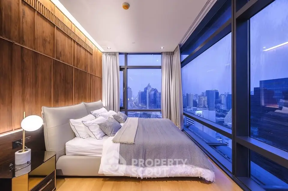 Luxurious bedroom with floor-to-ceiling windows offering stunning city views, modern decor, and elegant lighting.