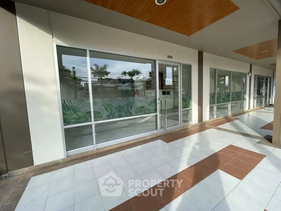 Modern commercial property with large glass windows and tiled walkway, ideal for retail or office space.