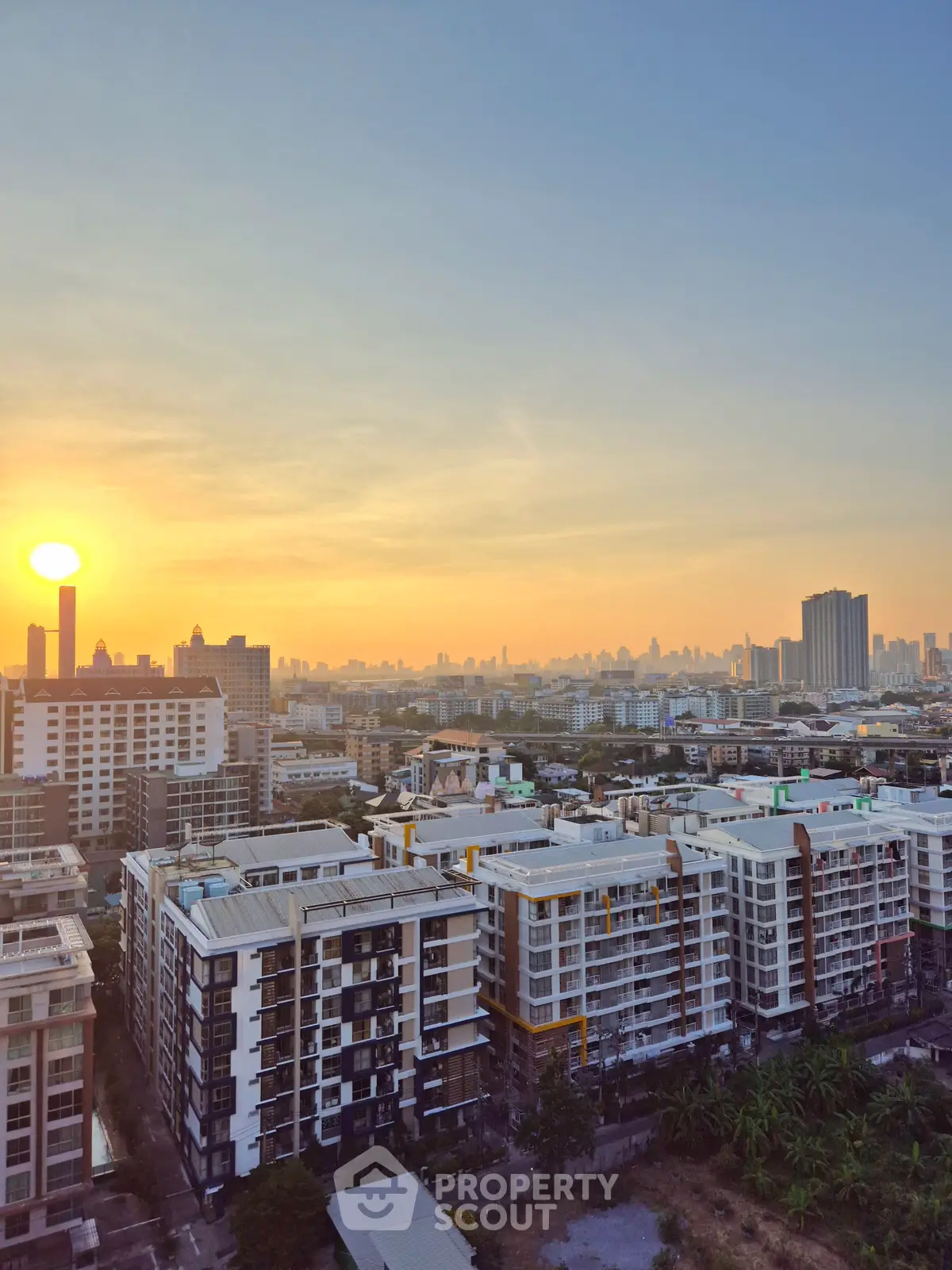 Stunning cityscape view from a high-rise building at sunset, showcasing urban skyline and vibrant colors.
