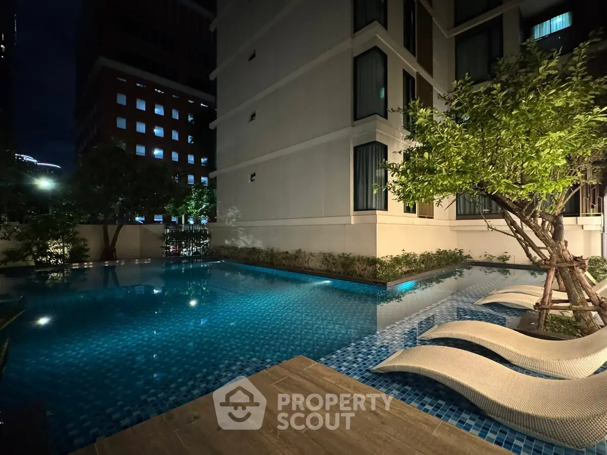 Luxurious nighttime poolside view with modern architecture and ambient lighting.