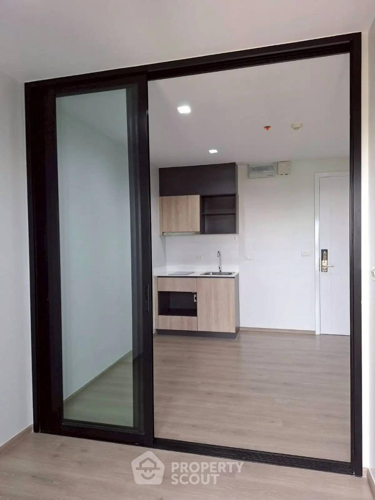 Modern apartment interior with sleek kitchen and sliding glass door