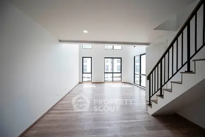 Spacious modern living room with large windows and wooden flooring