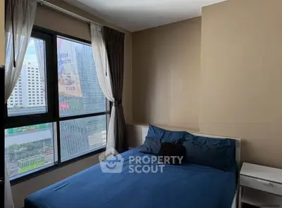 Modern bedroom with city view, featuring large windows and stylish decor.