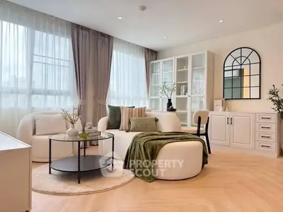 Elegant living room with modern furniture and large windows, featuring a cozy seating area and stylish decor.