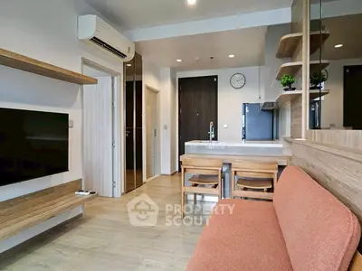 Modern living room with open kitchen, wooden accents, and cozy seating area.