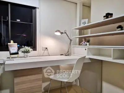 Modern study room with sleek desk, chair, and shelves in a cozy apartment.