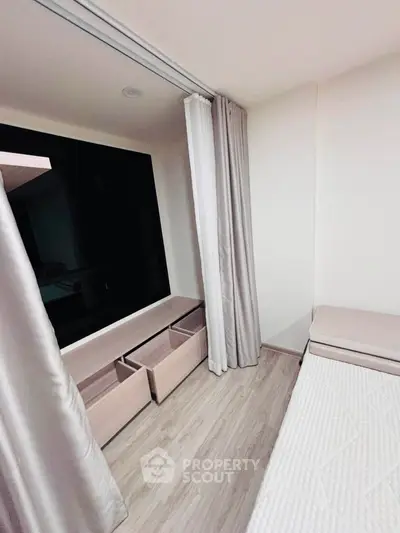 Modern bedroom with sleek design, featuring large window and elegant curtains, perfect for urban living.
