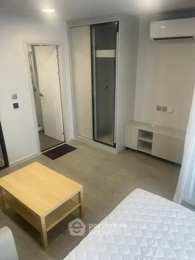 Modern minimalist bedroom with air conditioning and sleek furniture in a stylish apartment.