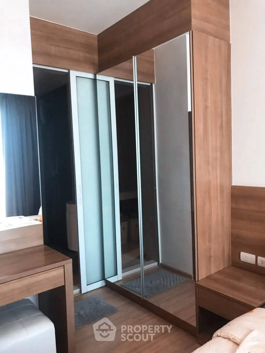 Modern bedroom with mirrored wardrobe and wooden accents