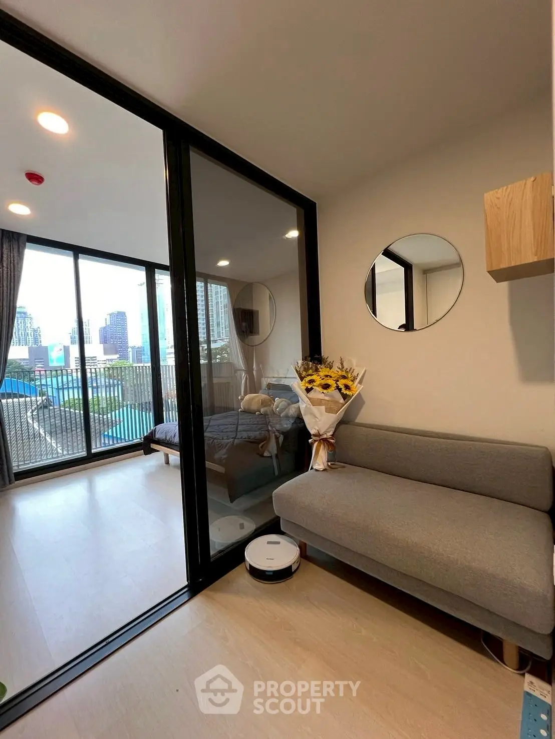Modern apartment with cozy living area and city view balcony, featuring stylish decor and natural light.