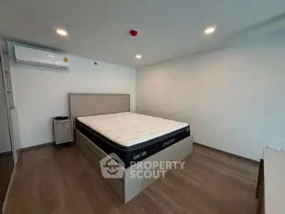 Spacious bedroom with modern design and ample natural light, featuring a comfortable bed and sleek flooring.