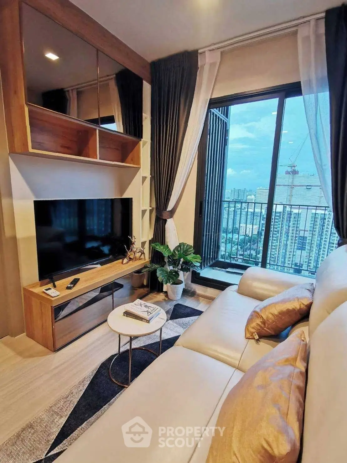 Modern living room with city view, elegant decor, and cozy seating area.