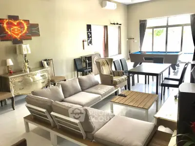 Spacious living room with modern decor and pool table, perfect for entertainment.