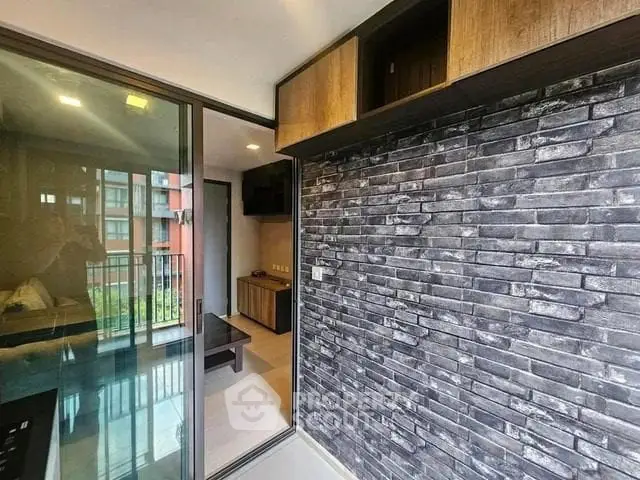Modern apartment interior with brick accent wall and balcony view