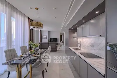 Luxurious open-plan kitchen and dining area with modern decor and elegant lighting.