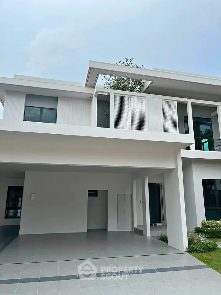 Modern two-story house with sleek design and spacious garage, featuring large windows and minimalist architecture.