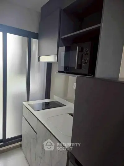 Modern kitchen with sleek cabinetry and built-in appliances in a compact layout.