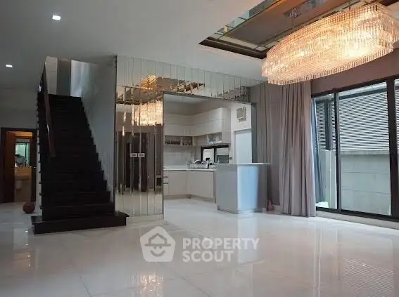 Luxurious modern living room with elegant chandelier and mirrored wall