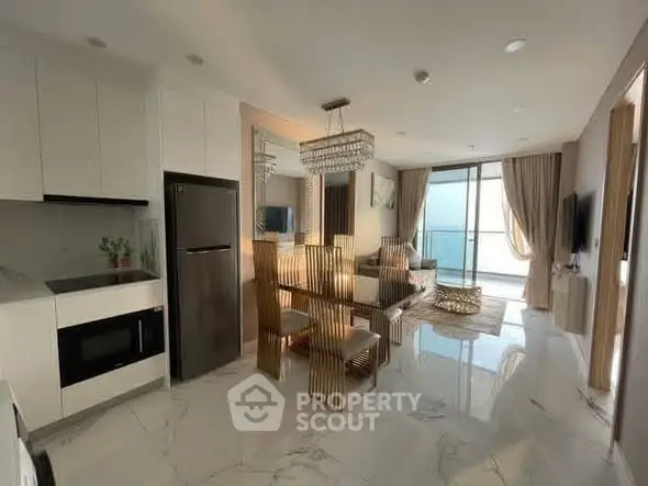 Luxurious open-plan living room with modern kitchen and elegant dining area, featuring floor-to-ceiling windows and chic decor.