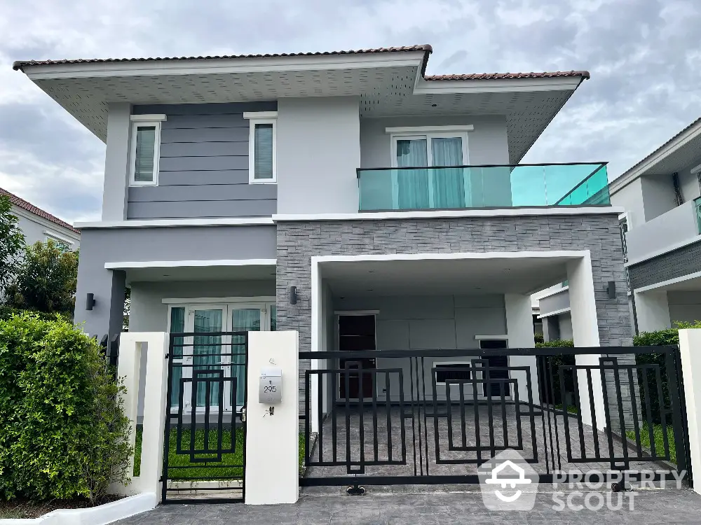 Modern two-story house with stylish facade and gated entrance in a serene neighborhood.