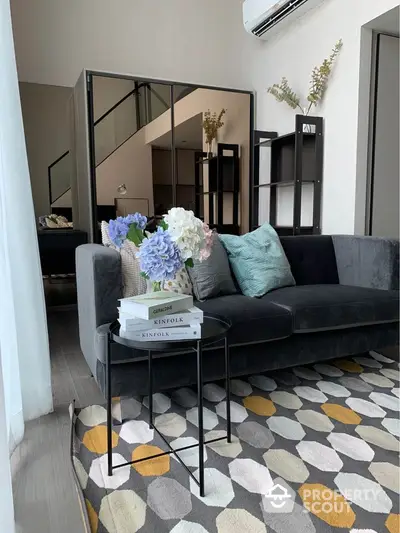 Stylish modern living room with plush sofa and geometric rug in elegant apartment.