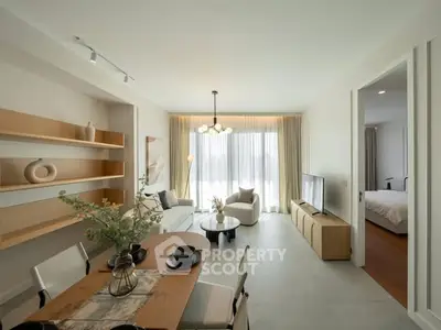 Modern open-plan living room with dining area, stylish decor, and natural light.