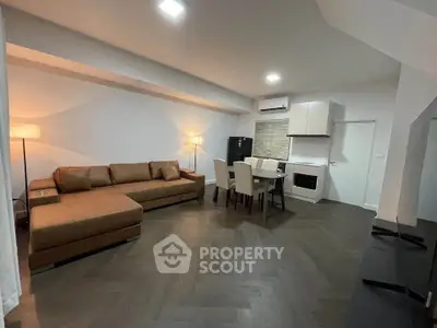 Modern open-plan living room with stylish furniture and integrated kitchen area, perfect for contemporary living.