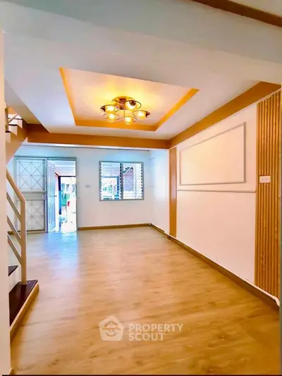 Spacious living room with modern lighting and wooden flooring in a stylish home.
