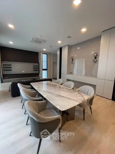 Luxurious modern dining room with elegant marble table and plush chairs, perfect for entertaining guests.