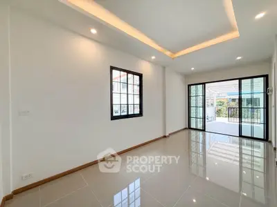 Spacious modern living room with large windows and glossy tiled floors, perfect for natural light and open living.