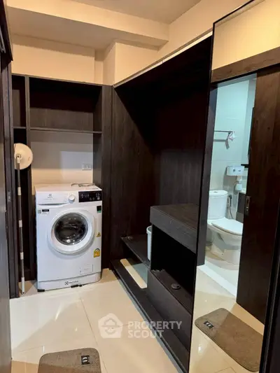 Modern bathroom with washing machine and sleek dark wood cabinetry