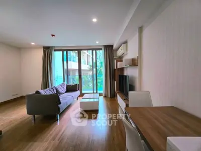 Spacious modern living room with large windows and stylish furniture in a luxury apartment.