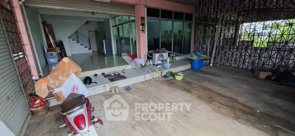Spacious garage area with potential for renovation and storage, featuring a view of the interior living space.