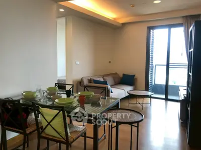 Modern living room with dining area and balcony access in a stylish apartment.