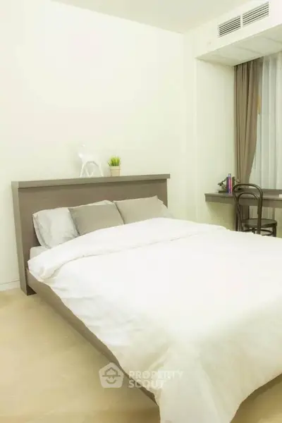 Cozy bedroom with modern decor and natural light, featuring a comfortable bed and stylish furnishings.