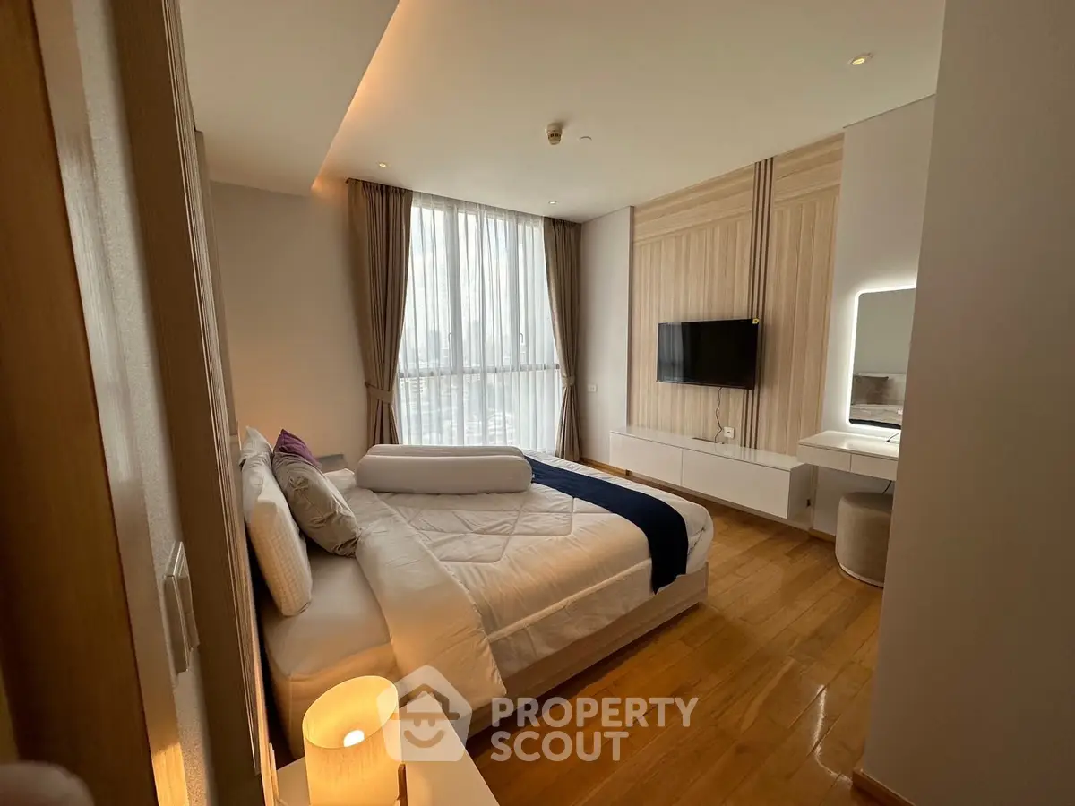 Luxurious bedroom with modern decor, large window, and elegant lighting in a high-end apartment.