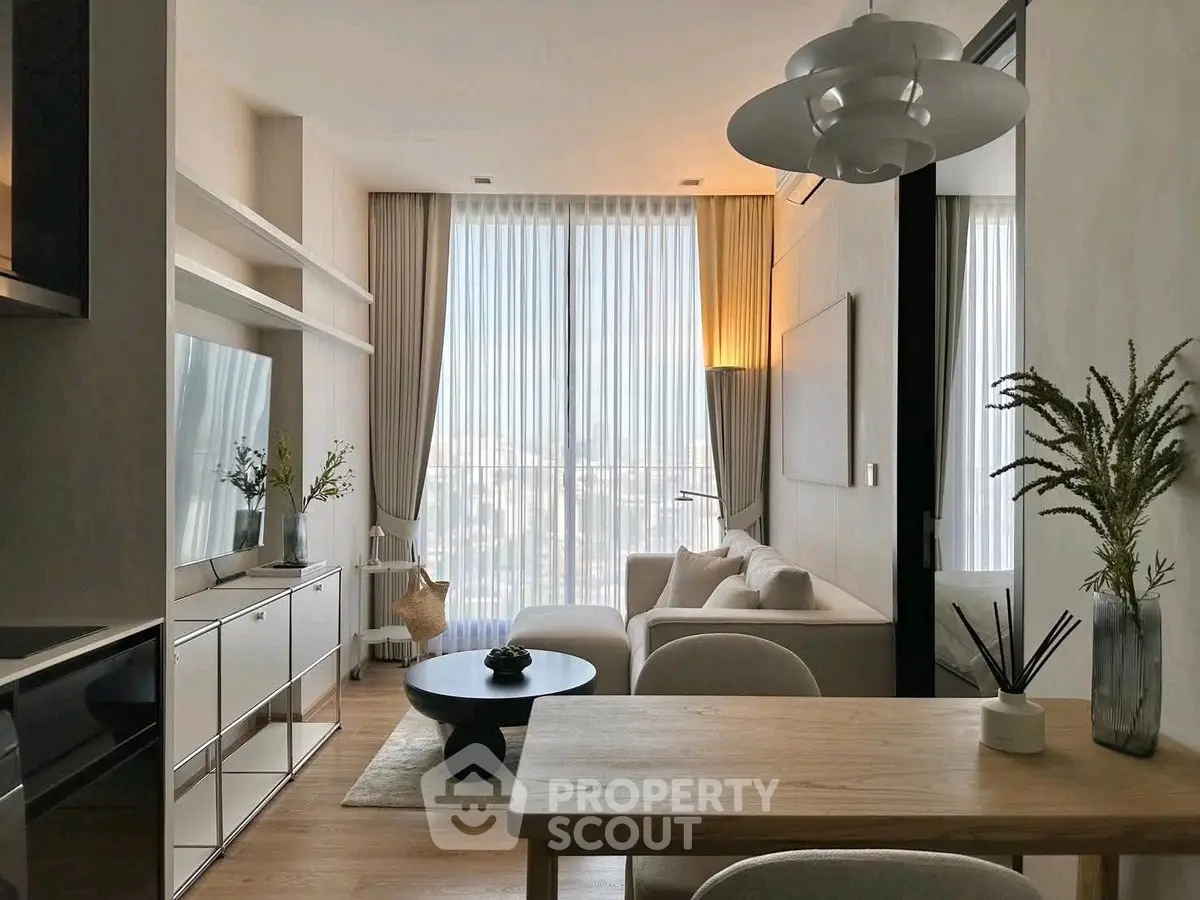 Modern living room with elegant decor and large windows offering natural light.