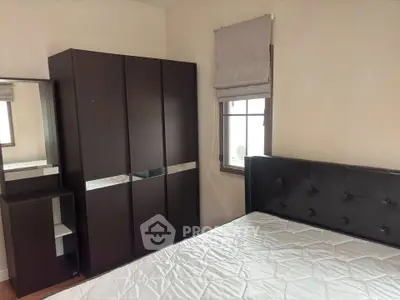 Cozy bedroom with modern dark wood furniture and large window