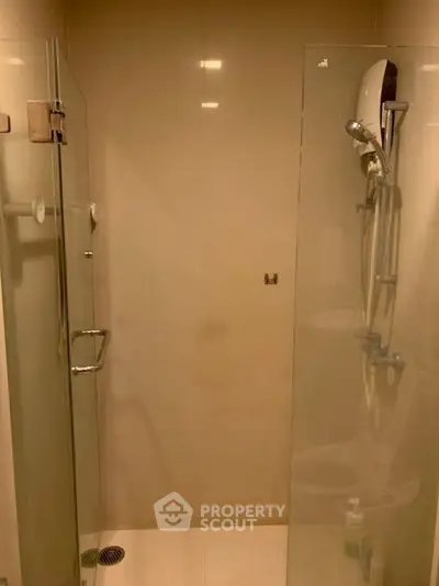 Modern bathroom with glass shower enclosure and sleek fixtures.