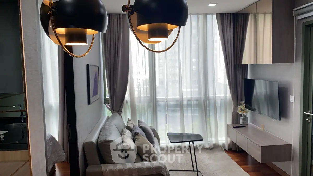 Modern living room with stylish lighting and floor-to-ceiling windows in a contemporary apartment.