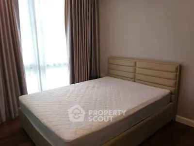 Spacious bedroom with elegant curtains and a comfortable bed in a modern apartment.