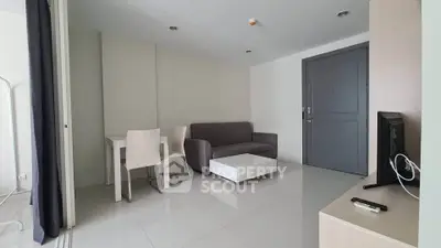 Modern living room with sleek furniture and minimalist design, featuring a cozy sofa and dining area.