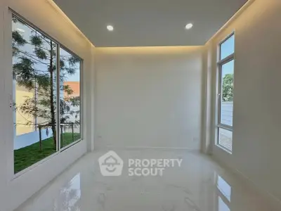 Bright and modern room with large windows and sleek tile flooring, perfect for a stylish living space.