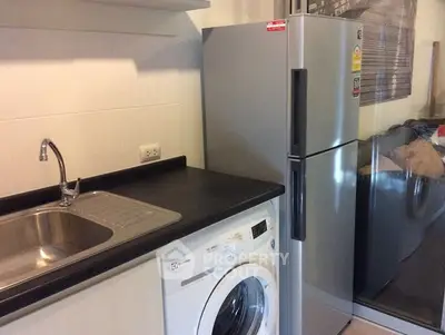 Modern kitchen with stainless steel fridge and washing machine