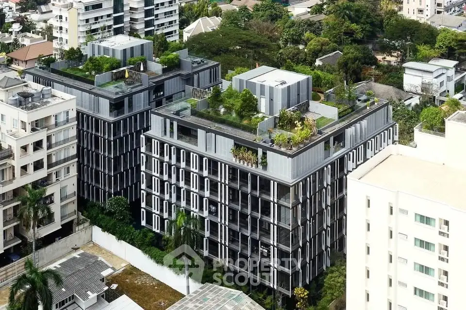 Modern urban apartment complex with lush rooftop gardens and sleek architectural design.