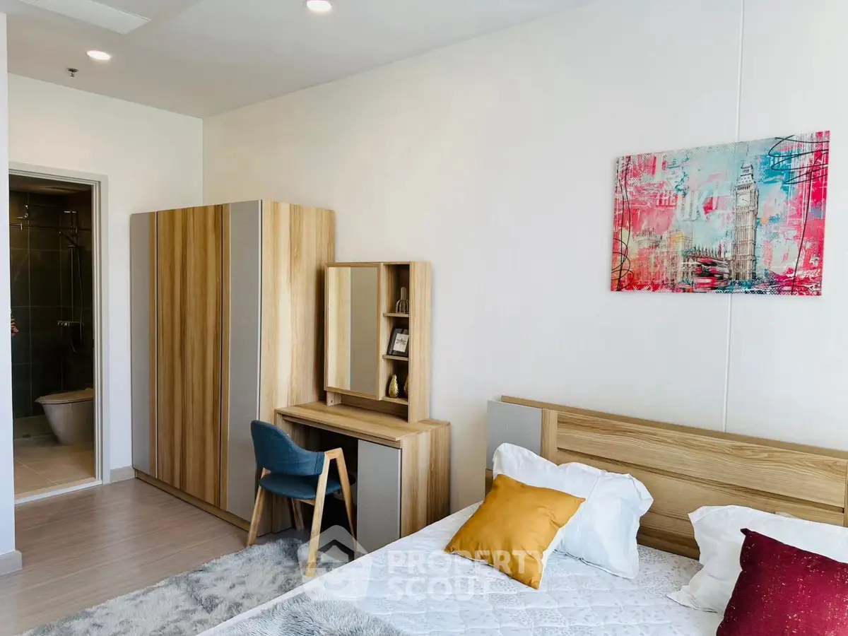 Modern bedroom with stylish wooden furniture and colorful artwork, featuring a cozy bed and a sleek wardrobe.