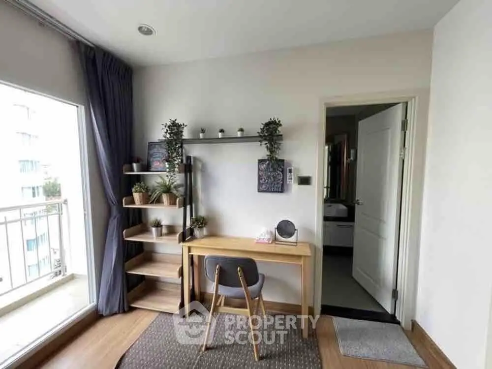 Modern study area with desk, chair, and plants near a balcony in a stylish apartment.