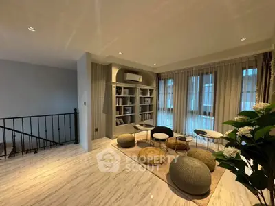 Spacious living room with modern decor, featuring cozy seating and elegant shelving, perfect for relaxation.