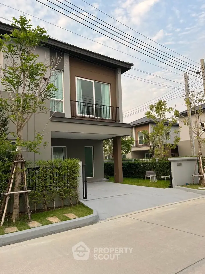 Modern two-story house with landscaped front yard and driveway in a suburban neighborhood.